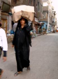 En ægyptisk kvinde bærer noget på hendes hoved